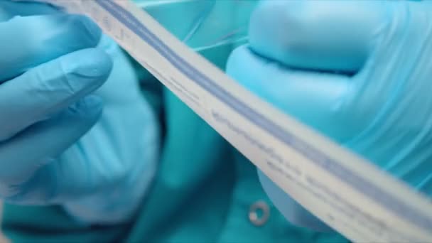 Медицинский работник открывает пакет с ватным тампоном в больнице — стоковое видео
