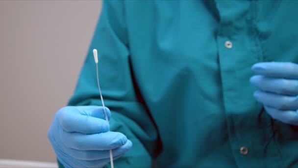 Медсестра в защитном костюме сгибает мазок для образца коронавируса — стоковое видео