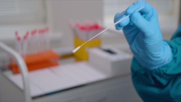 Pielęgniarka w rękawiczkach pokazuje wymaz z próbki wymazu koronawirusa — Wideo stockowe