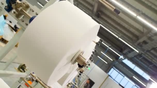 Rörelse förbi stora bobbiner med vit spunbond för att sy uniform — Stockvideo