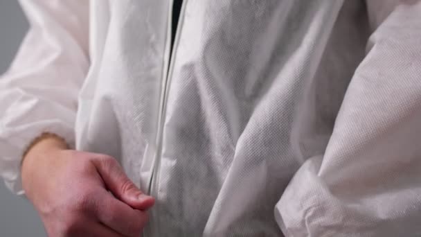 Läkare blixtlås vit engångs skyddskläder på grå — Stockvideo