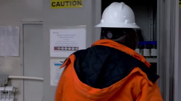 Εργαζόμενος με πορτοκαλί στολή ανοίγει περίπτωση με υγρά χημικά — Αρχείο Βίντεο