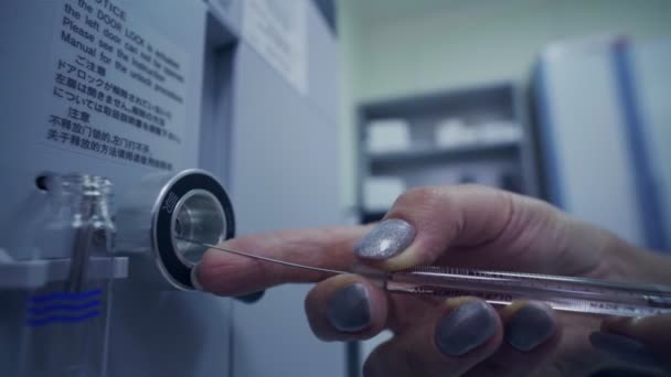 महिला सिरिंजसह चाचणी मशीनमध्ये द्रव ठेवते — स्टॉक व्हिडिओ