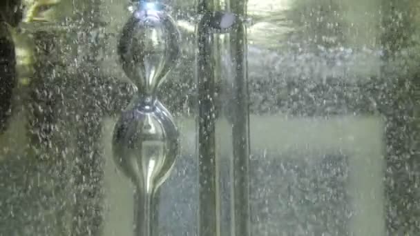 Bubblor stiger upp nära glasröret och kolven i klart vatten — Stockvideo