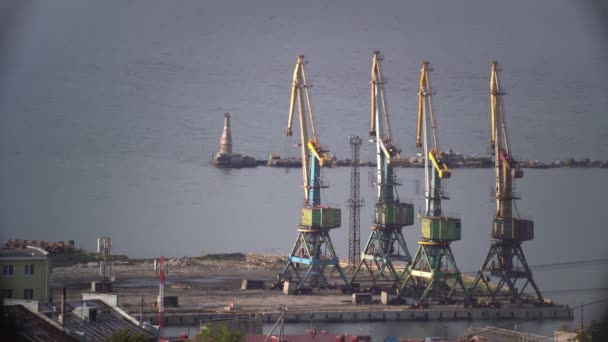 Εξέδρες γεώτρησης σε κοιτάσματα πετρελαίου στην ακτή του ωκεανού κοντά στον φάρο — Αρχείο Βίντεο