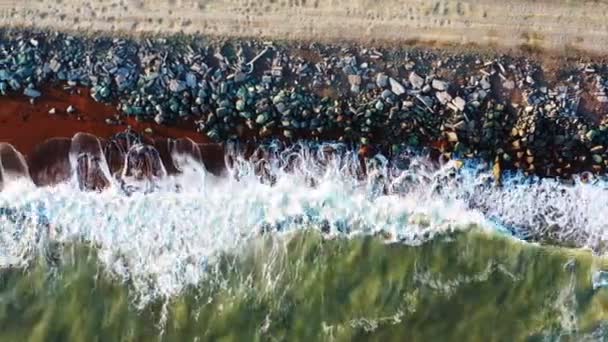 Wspaniałe fale morskie z białą pianką na plaży ze skałami — Wideo stockowe