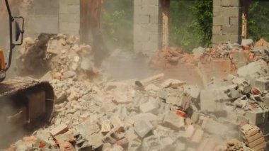 Kazı kovası yıkım alanındaki tuğla kalıntılarını kazıyor