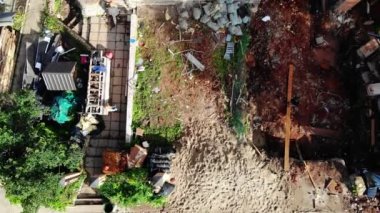 İnşaatçılar yıkım alanındaki terk edilmiş kulübenin önünden geçiyorlar.