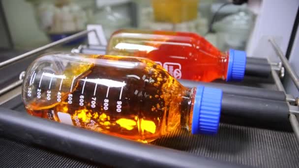 Sacudiendo botellas con líquidos de colores con equipo de prueba — Vídeos de Stock