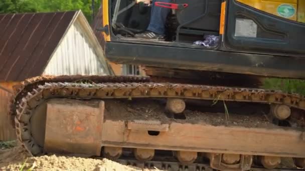 Excavator with caterpillar tracks and man at demolition site — Stock Video