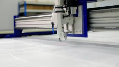 Otomatik kesici dükkanda tıbbi kıyafetler için elementler üretiyor