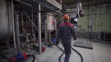 İşçi fabrikada varili yağ ürünleriyle doldurmaya geliyor.