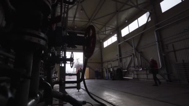 Silhouette eines Arbeiters, der an einer geräumigen Lagerhalle entlanggeht — Stockvideo