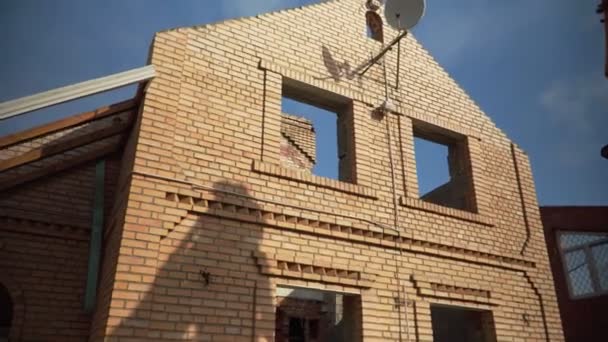 Покинутий цегляний будинок з супутниковою тарілкою на сайті знесення — стокове відео