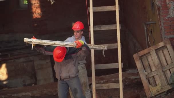 Mitarbeiter tragen Fenster aus altem Häuschen an Abrissstelle — Stockvideo