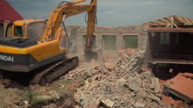 Sarı kazıcı terk edilmiş binanın enkazını temizliyor
