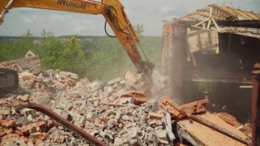 Güçlü kazıcı toz bulutu içindeki kovayla enkazı kürekliyor