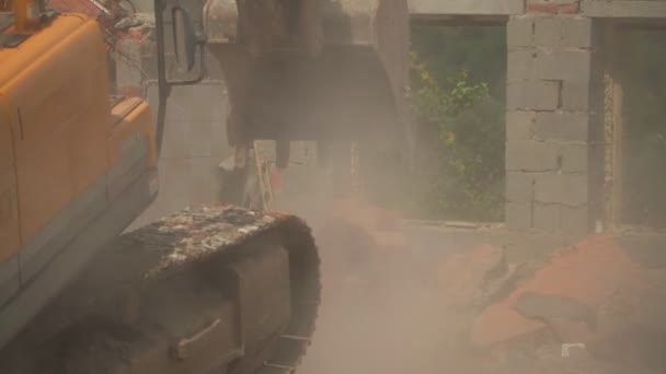 Экскаватор лопаты обломки старого жилого дома на месте — стоковое видео