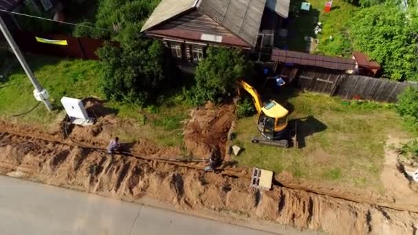 Il team di lavoratori posa cavi per la casa e scava scavatrici trincea — Video Stock