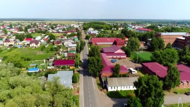 Automóviles conducen a lo largo de camino vacío a través de gran pueblo — Vídeo de stock