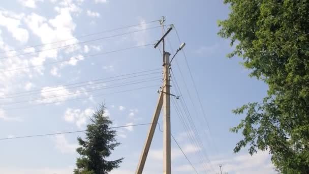 Líneas de transmisión de electricidad en poste cerca de valla en la aldea — Vídeo de stock