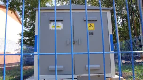 Construção de subestação elétrica atrás de cerca azul na rua — Vídeo de Stock