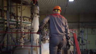 Solunum cihazı olan işçiler, inşa edilmiş tankın kapağını açmak için yürür