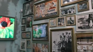 Televizyon seti ve fotoğraf koleksiyonu kafenin duvarında asılı.
