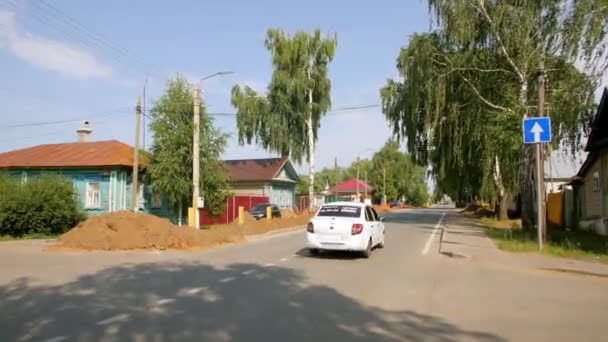 Белая машина едет по пустой деревенской улице с траншеей — стоковое видео