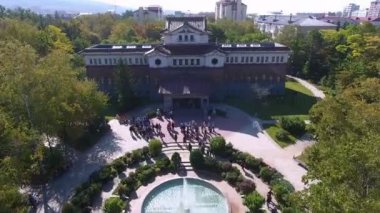 Yeşil Park 'taki eski binanın bahçesinde insanlar ve çeşme