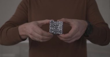 Rubik küpün parçalarını farklı üçgenlerle döndüren kişi
