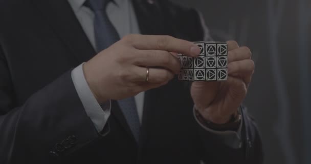 Businessman solves Rubik cube with triangles in office — Stock Video