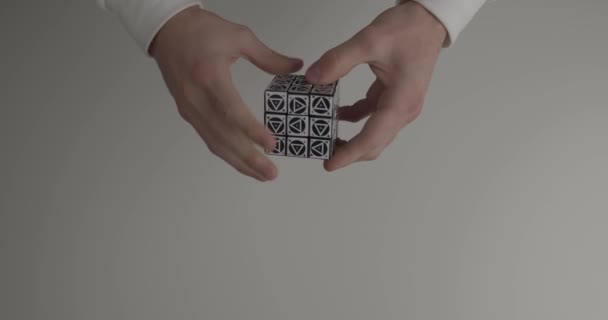 Guy risolve Rubik cubo puzzle con triangoli sulla luce — Video Stock