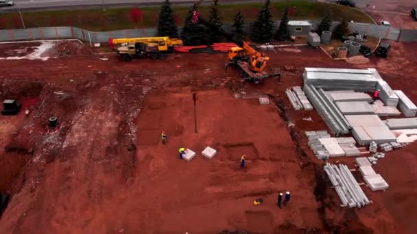 Trabajadores cerca de bloque de hormigón en el sitio de construcción de gasolineras — Vídeos de Stock