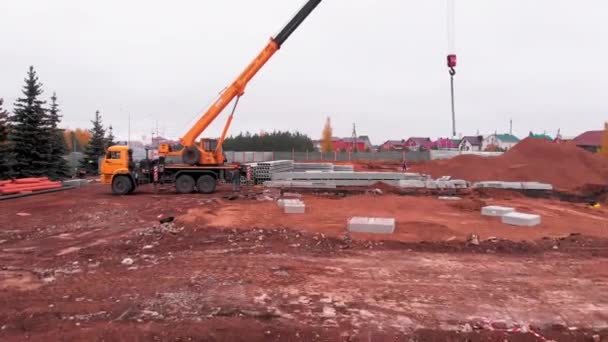Žlutý jeřáb s kabely na háku na staveništi — Stock video