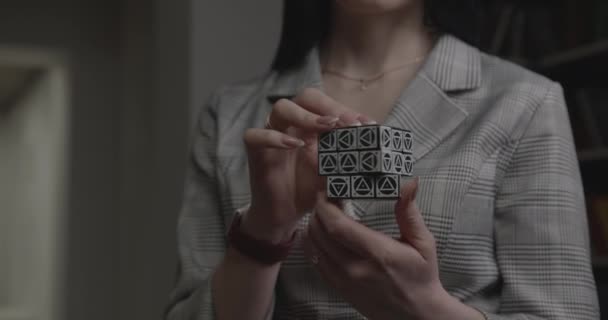 Женщина в элегантной одежде решает кубик Рубика в офисе компании — стоковое видео