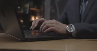 Yetenekli yönetici dizüstü bilgisayarla ahşap masada oturuyor.