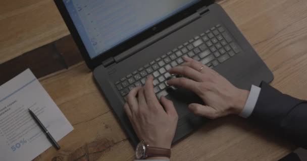 Бизнесмен с наручными часами на ноутбуке за столом — стоковое видео