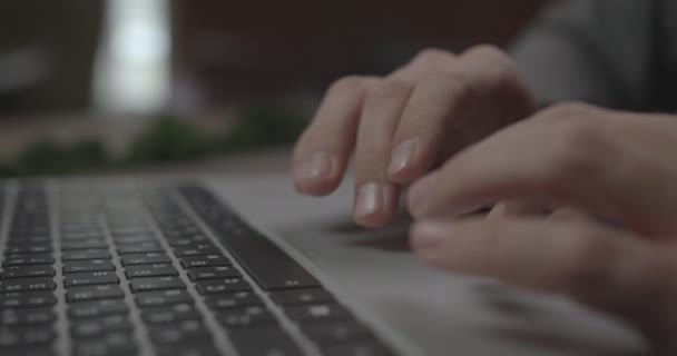 男はオフィスのテーブルに座ってノートパソコンのタッチパッドを使用します。 — ストック動画