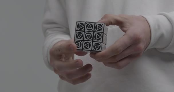 Persona gira lati del puzzle cubo Rubik su sfondo chiaro — Video Stock