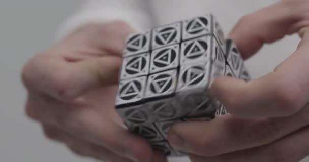 Människan löser Rubik kub pussel med olika trianglar på sidorna — Stockvideo