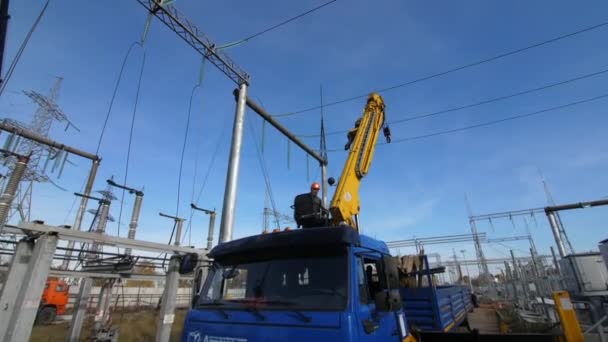 Uomini vicino braccio giallo della gru camion per riparare sottostazione — Video Stock