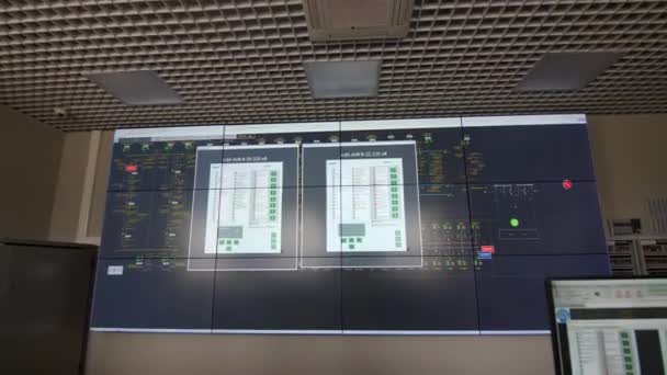 Layar menampilkan data di dinding di ruang kontrol dengan karyawan — Stok Video