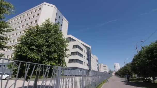 Beweging langs trottoir langs wooncomplex op zonnige dag — Stockvideo