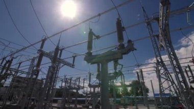 Mavi gökyüzüne karşı izolatörlü ve elektrik hatlı kutup