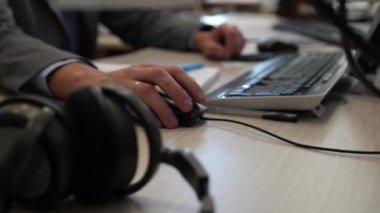 İşçi ışık ofisindeki bilgisayarda çalışan fareyi hareket ettirir