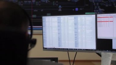 Operatör, veri içeren monitörlerin yanında oturan ekipmanları kontrol eder