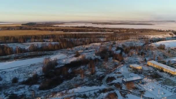 Collines enneigées avec arbres nus près de l'usine de traitement des eaux usées — Video