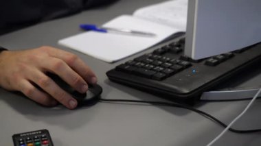 Çalışan, ofisteki masada bilgisayarda çalışan fareyi kullanır