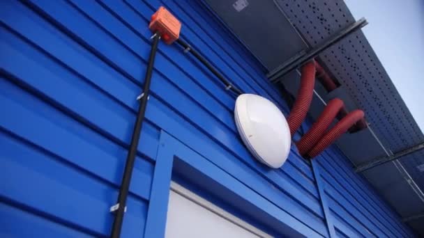 Linterna sobre la entrada en la pared azul del edificio del almacén — Vídeos de Stock